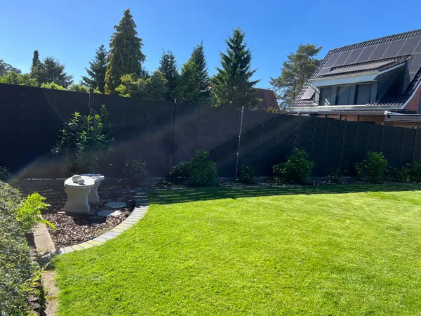 Fertiger Garten mit WPC-Sichtschutz, bepflanztem Beet und Rollrasen